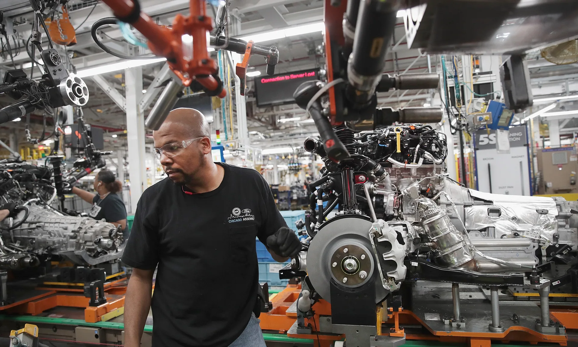Manufacturing floor with workers operating heavy machinery representing workplace safety and AI-powered accident prevention